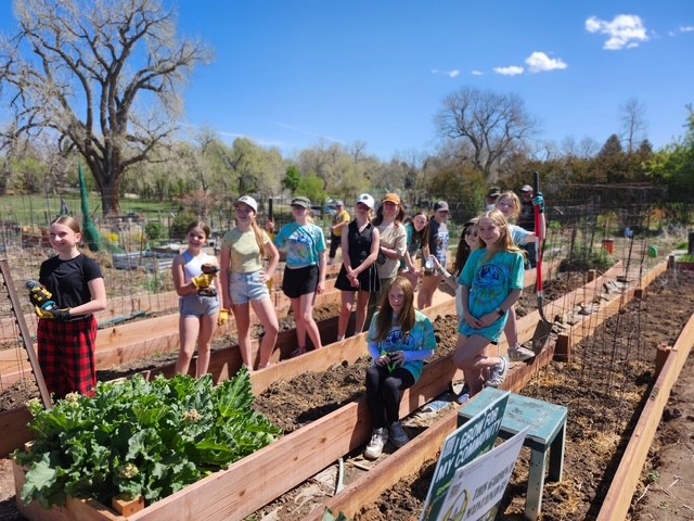 Members of Girl Scout Troop 65595 pose beside the raised garden beds they built and donated to the Arapahoe County Master Gardener volunteers.